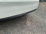 a white car that is parked on the side of the road