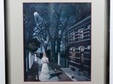 framed photograph of a woman in a white dress walking down a street at night