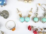 many different types of earrings and rings on the table