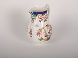 a small white vase with a floral design on it