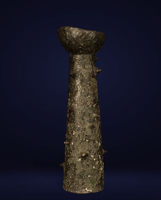 une ancienne statue en bronze représentant une femme tenant un bol sur la tête