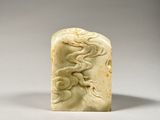 a white jade carving of a woman with a flower in her hair