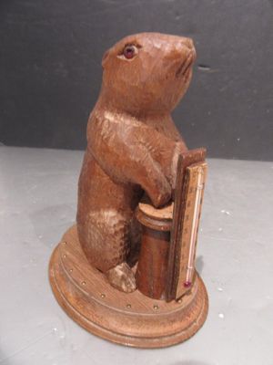 statue d'un ours tenant un livre posé sur une table
