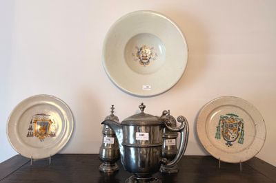 trois assiettes en argent et une théière en argent posées sur une table