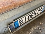 a rusted metal trailer with a number plate on it