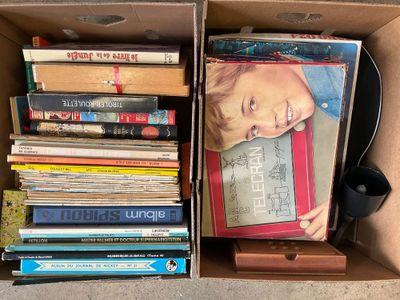 a cardboard box full of books and a phone