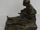 statue of a woman sitting on a rock with a dog