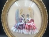 une photo représentant deux femmes en robe, dans un cadre doré