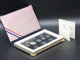 a box of coins sitting on a table next to a card