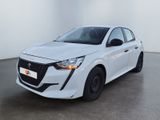 Une voiture blanche est garée dans une grande pièce aux murs blancs.