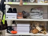 many pairs of shoes on the shelves in the store