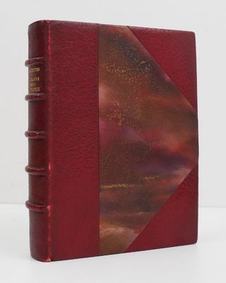 a red book sitting on top of a table next to a white wall