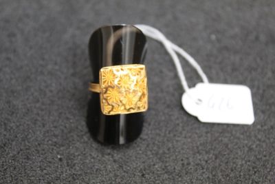 une bague noire ornée d'un motif doré et d'une étiquette de prix