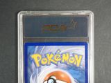 the pokemon card is in a plastic holder on a table