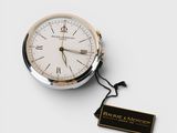 an image of a silver and gold pocket watch with a tag on it