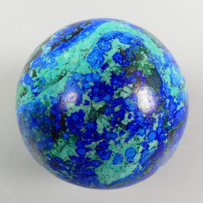 an image of a blue and green marble ball on a white surface