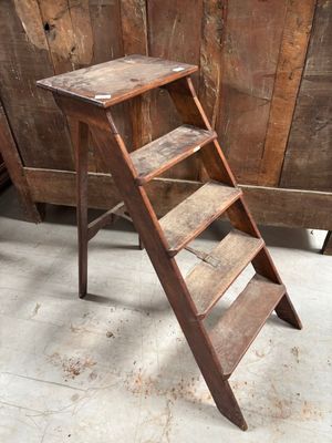 un petit tabouret en bois surmonté d'une échelle