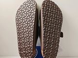 the soles of a pair of brown shoes on a blue box