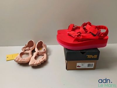 des chaussons de danse roses et une boîte de chaussures rouges posées sur une table