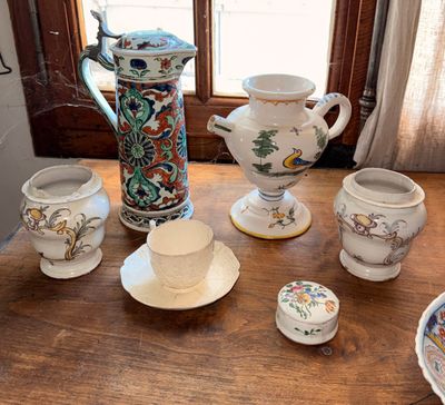 une table en bois sur laquelle sont disposés de nombreux vases de styles variés
