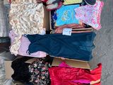 a cardboard box full of clothes and shoes on the street