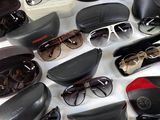 many pairs of sunglasses sitting on a white surface
