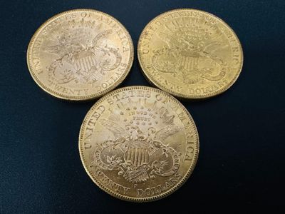 three gold coins sitting on top of each other on a table