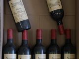 plusieurs bouteilles de vin dans une boîte en carton munie d'une poignée rouge