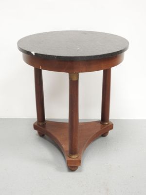 une image représentant une table ronde au plateau en marbre noir