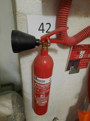 a fire extinguisor attached to a wall next to a fire hydrant