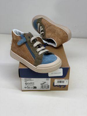 une paire de chaussures pour enfants dans une boîte posée sur une surface blanche