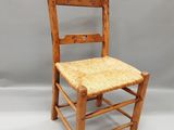 une vieille chaise en bois avec une assise tressée sur fond blanc