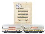 two toy trains sitting next to each other in front of a box