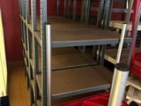 many shelves with red bins on them in a room