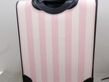 a pink suitcase sitting on the floor with a black handle