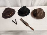 three hats on a table with a knife and a razor