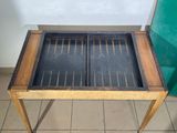 a wooden table with a glass top on a tiled floor