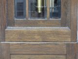 a wooden door with a glass window and a clock on it