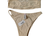 une paire de bikinis beige clair avec leurs étiquettes, sur fond blanc