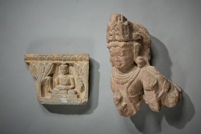 une petite statue représentant un homme coiffé d'une couronne, accrochée à un mur