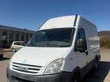 the white van is parked in the parking lot near the building