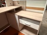 an image of a corner desk with shelves and drawers