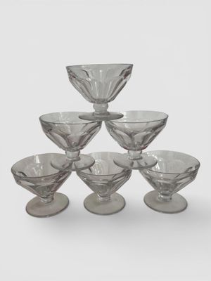 une pyramide de bols en verre posée sur une surface blanche