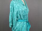 a mannequin torso with a green blouse on a mannequin stand