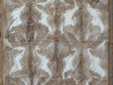 the rug is made of brown and white fur with white spots