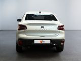the rear end of a white car in a white room