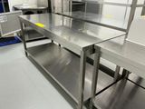 une grande table en acier inoxydable au milieu d'une cuisine