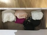 a wooden box filled with underwear and a pair of shoes