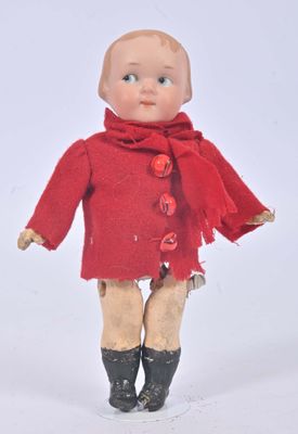 a small doll that is wearing a red coat and boots
