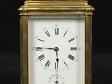 an image of a small brass clock with roman numerals